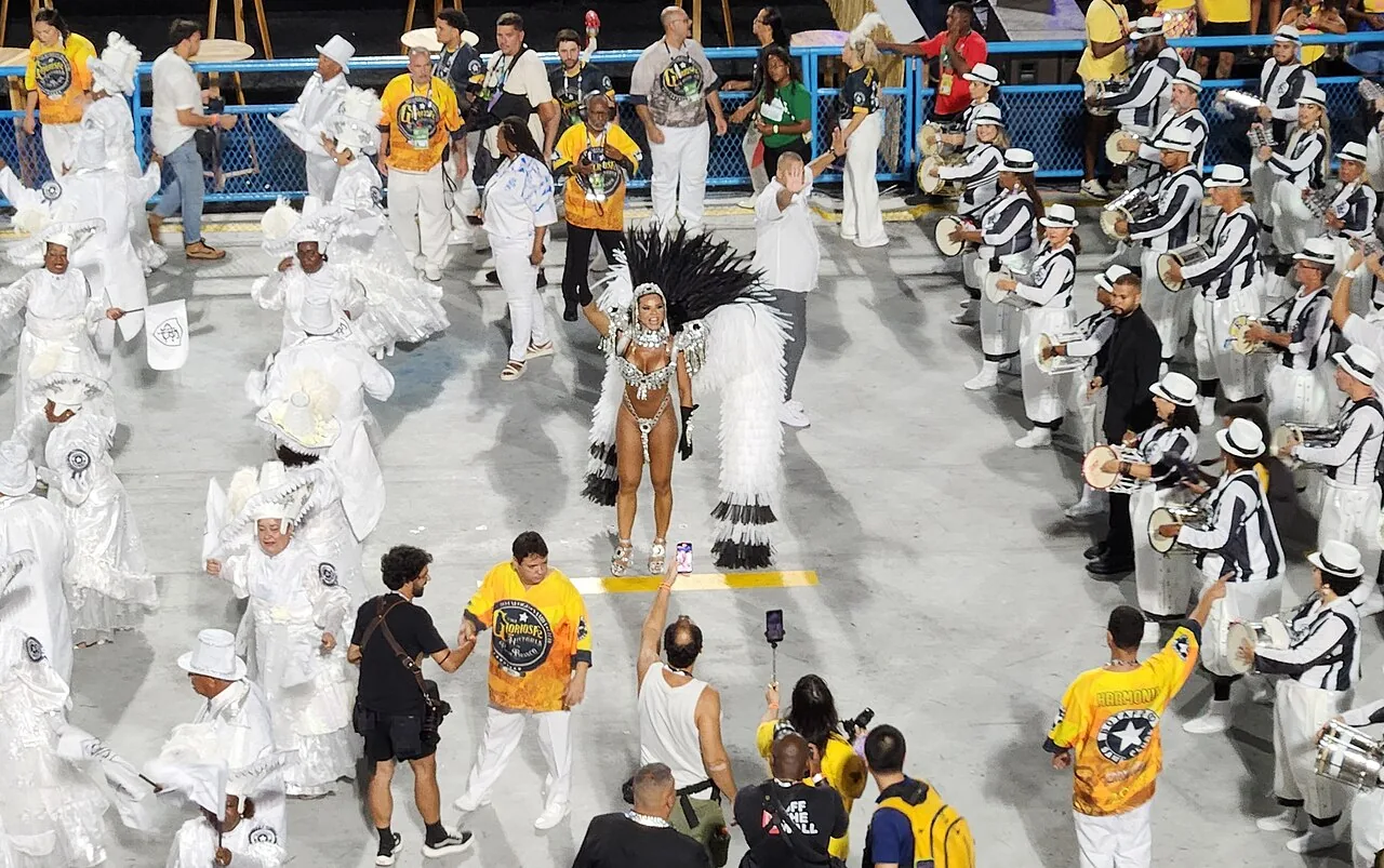 Desfile de escola de samba no Carnaval do Rio de Janeiro, com integrantes em fantasias coloridas na avenida