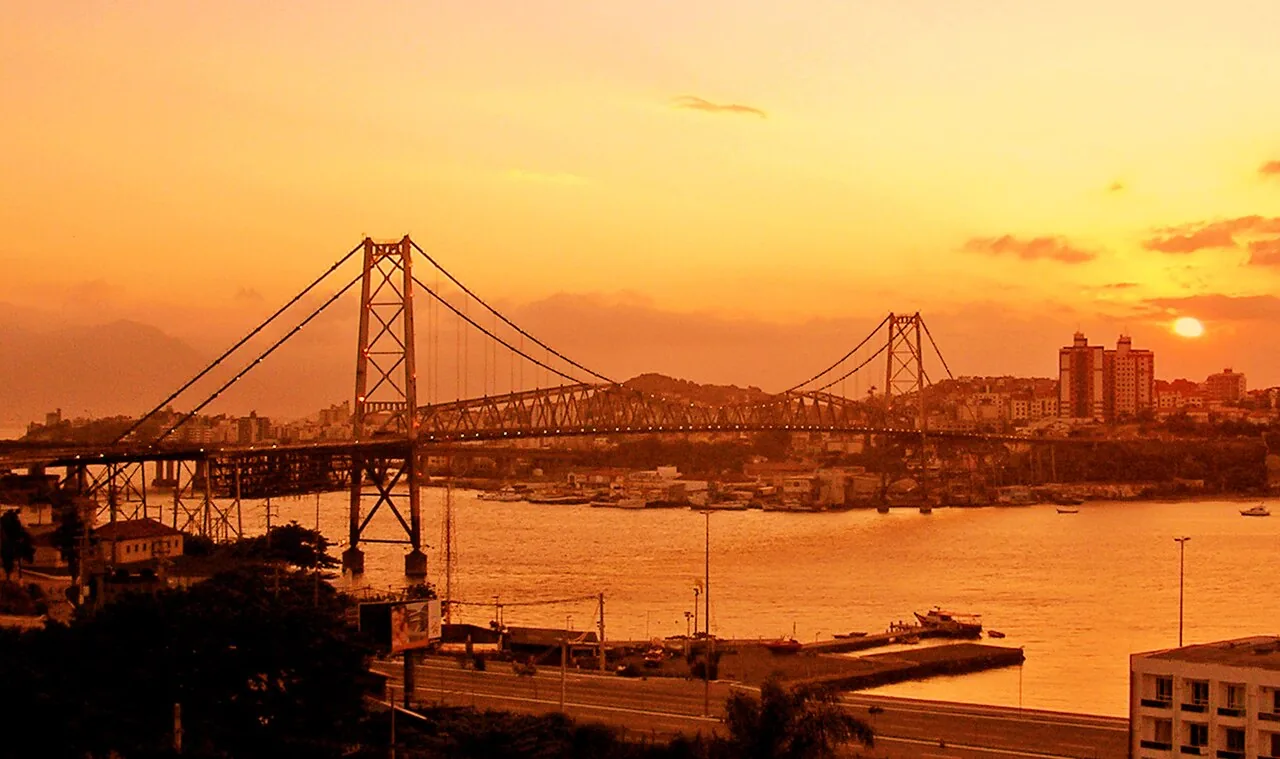 Ponte Hercílio Luz iluminada ao pôr do sol, ligando a ilha ao continente em Florianópolis, Santa Catarina