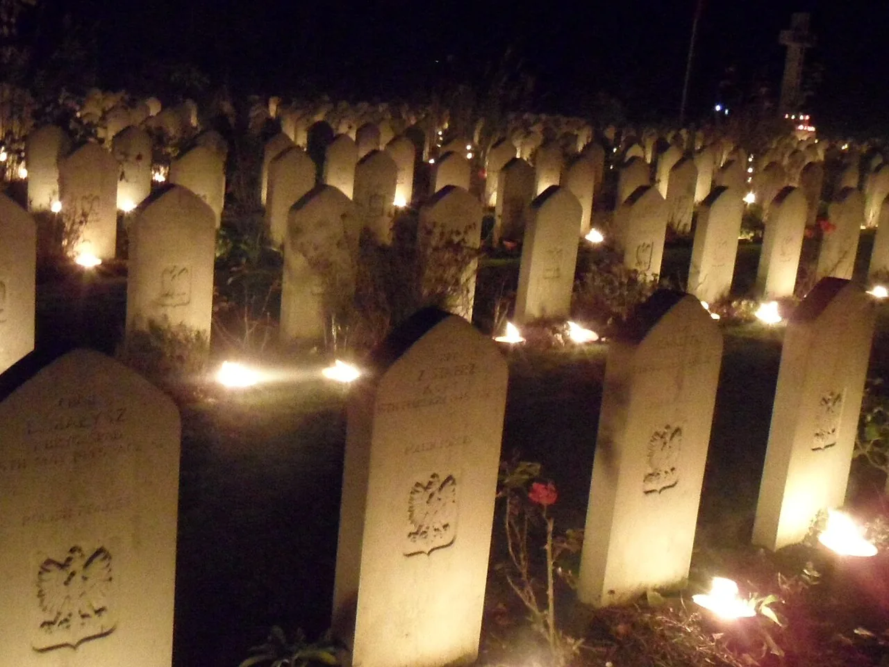 Velas acesas sobre os túmulos durante a cerimônia do Dia de Finados, costume de homenagem à memória dos que já partiram