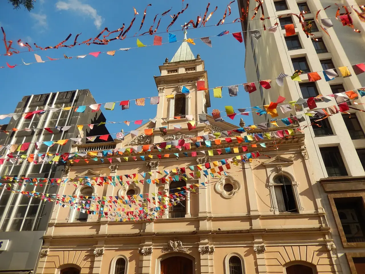 Fachada de igreja enfeitada com bandeirinhas coloridas de festa junina