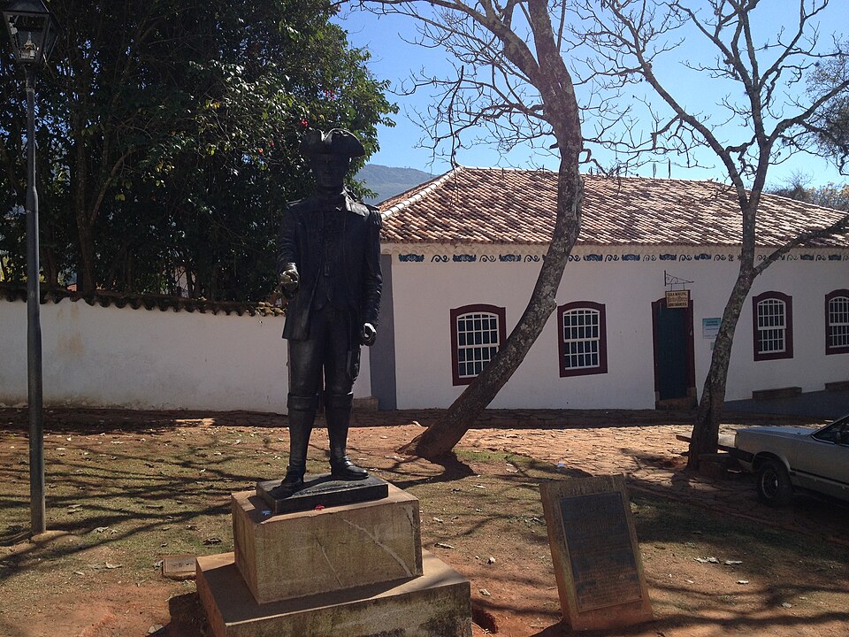 Estátua de bronze diante de uma casa colonial