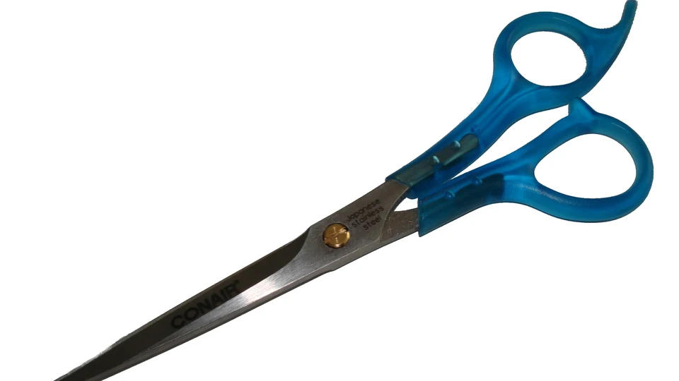 Tesoura de cortar cabelo com cabo azul sobre fundo branco