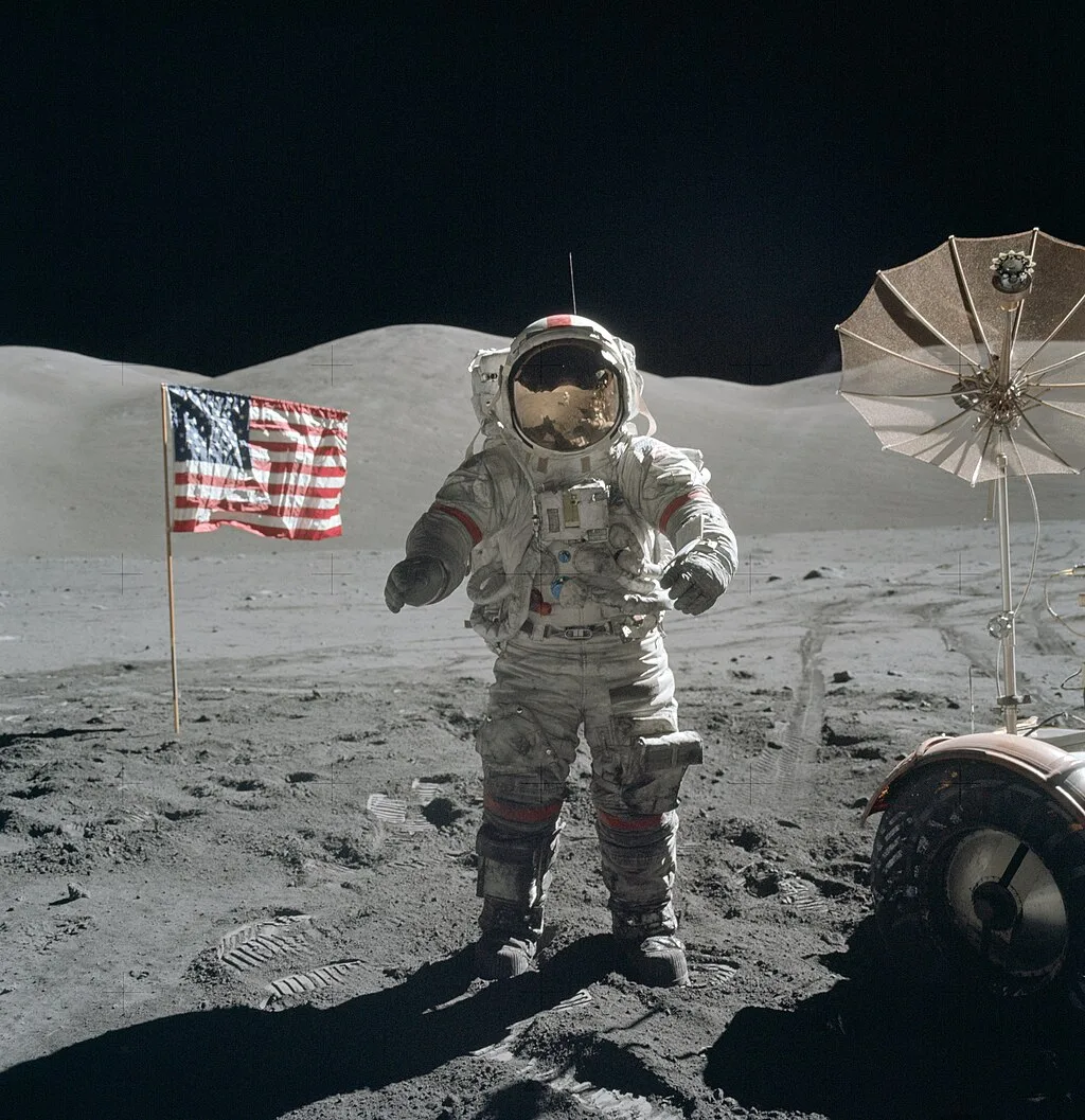 Astronauta Eugene Cernan trabalhando na superfície lunar durante a missão Apollo 17, ao lado do veículo Lunar Roving Vehicle.